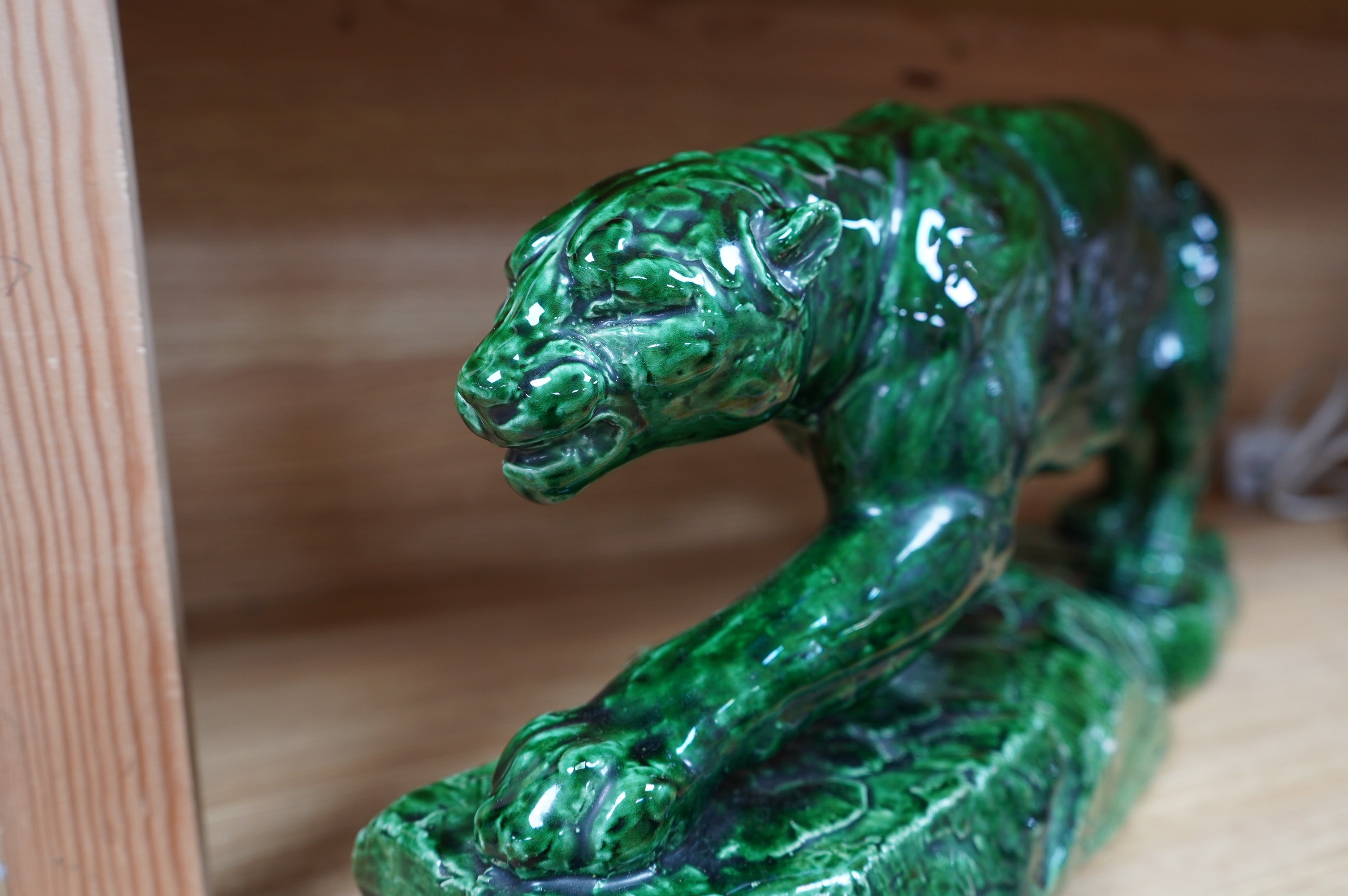 A French green glazed earthenware panther, indistinctly signed, 55cm wide. Condition - good